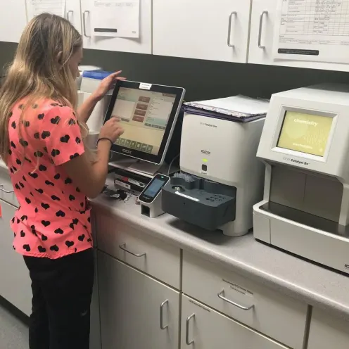  Calabasas Animal Clinic Lab that shows medical equipment and a female staff member wearing pink with polka dot shirt punching something into the computer